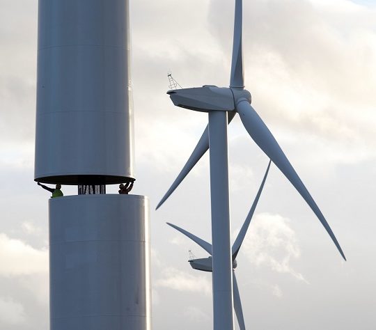 An image showing two men helping to build a wind turbine in County Durham