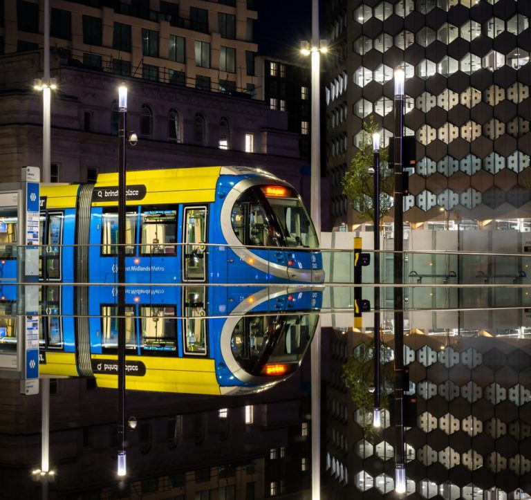 A Birmingham tram reflected in a wet platform