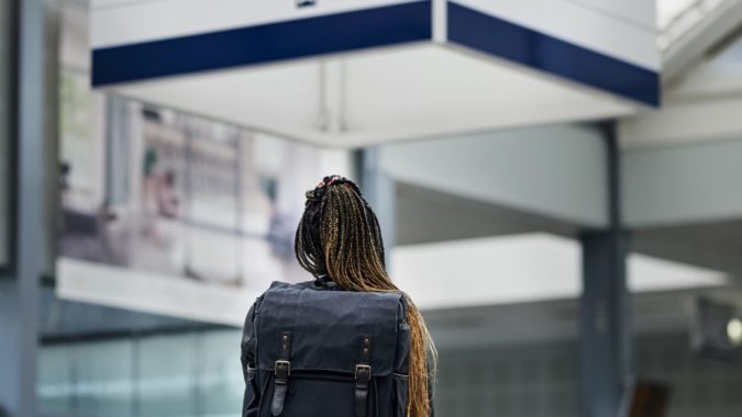 Picture of a woman at a station looking at a sign