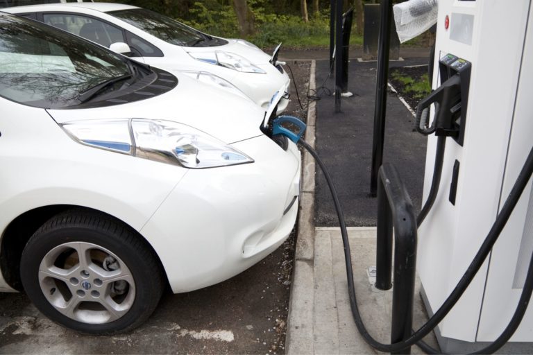 Two white EV cars charging at a chargepoint