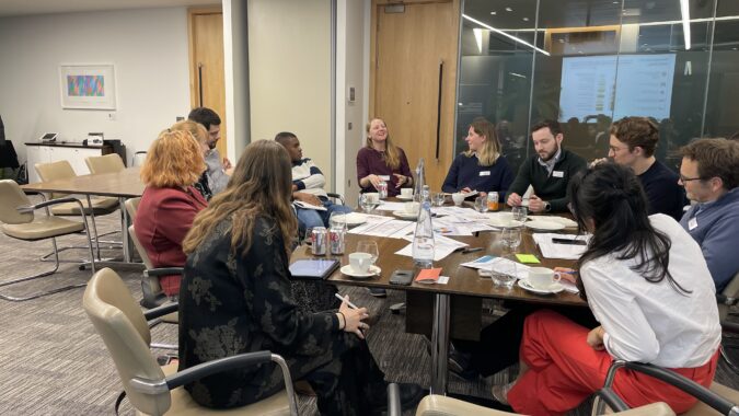 Young Professionals Panel members and guests discuss pathways to net zero - group seated in a meeting room in discussion, London, March 2023