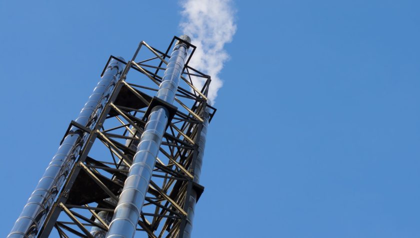 An industrial chimney with steam coming from it