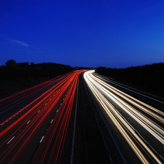 A motorway at night showing car headlights