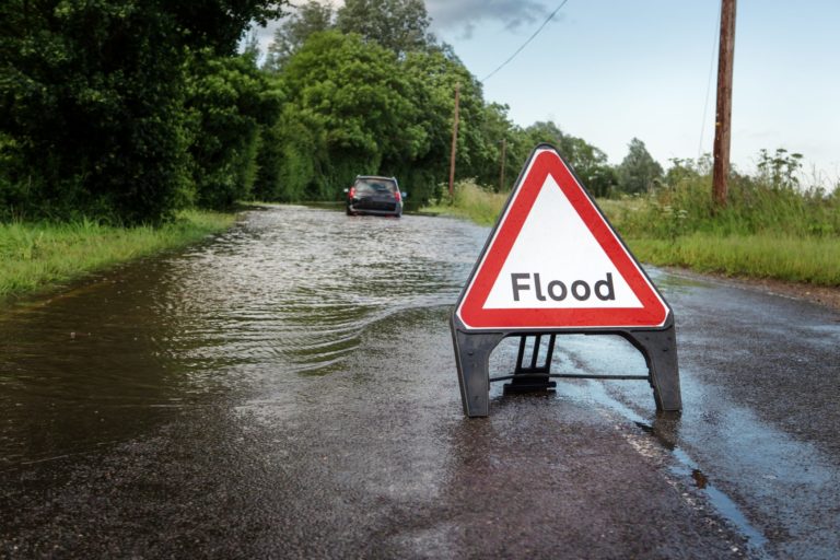A sign for flood on a flooded road