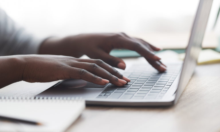 Close up of woman typing on a computer