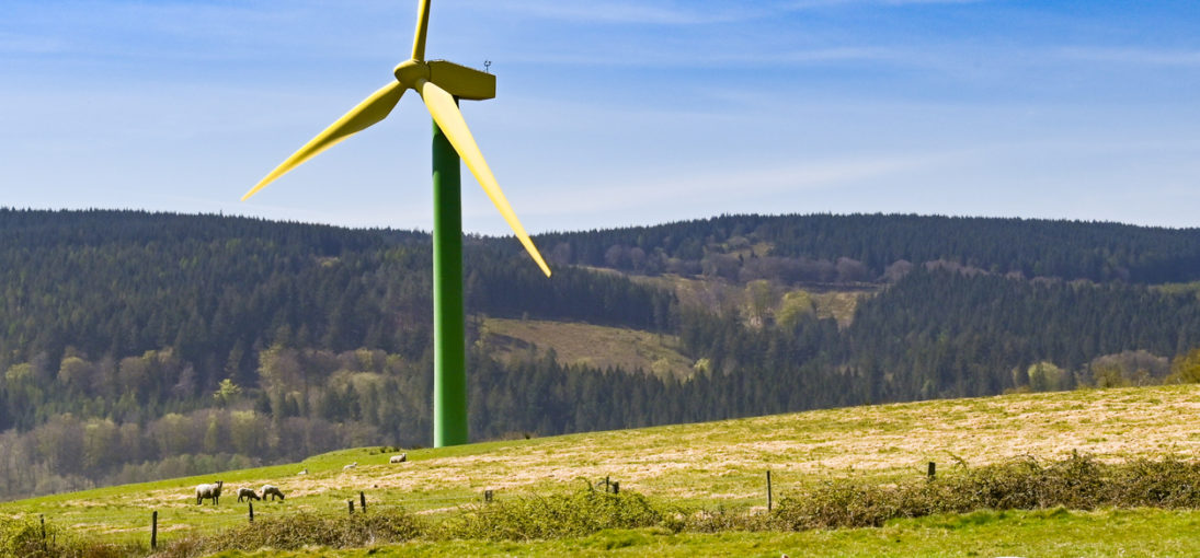 Yellow and green wind turbine against countryside backdrop