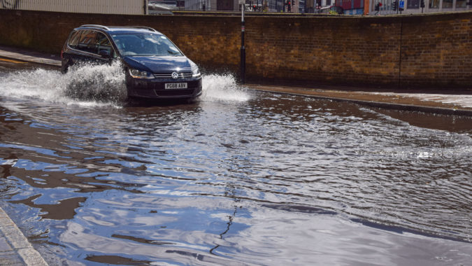 A car splashes through a flooded Farringdon Lane in central London after a day of heavy rain.