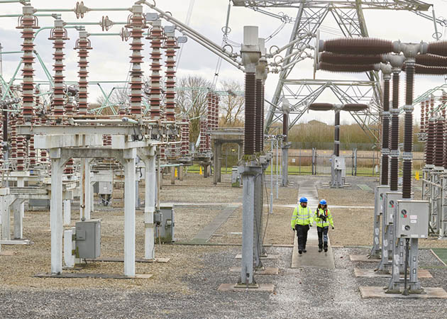 A UK electricity substation with workers