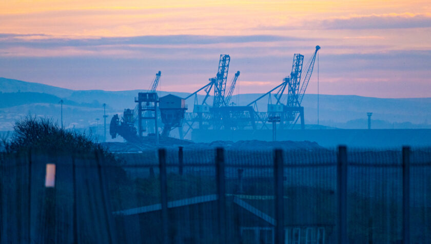 Scene showing industrial cranes silhouetted at sunset over Teessport, Middlesbrough