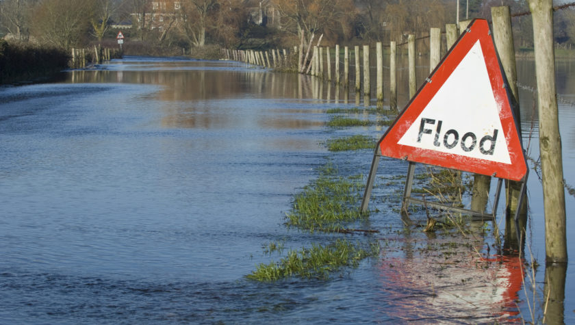 A flooding sign on a flooded country road