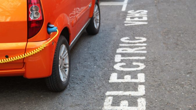 A car parked in a bay reserved for charging electric vehicles