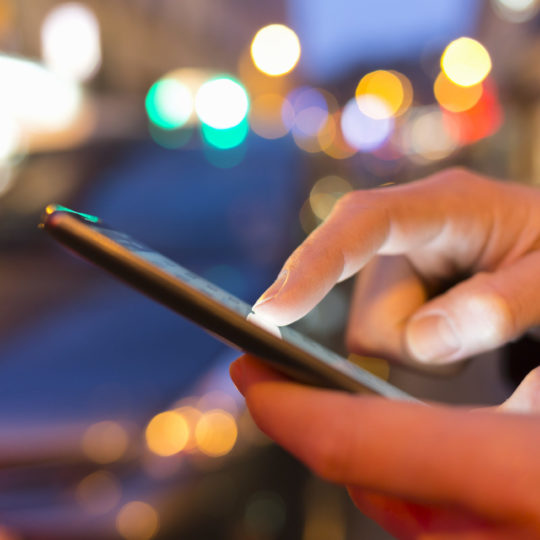 close up of male hands nightlight smartphone