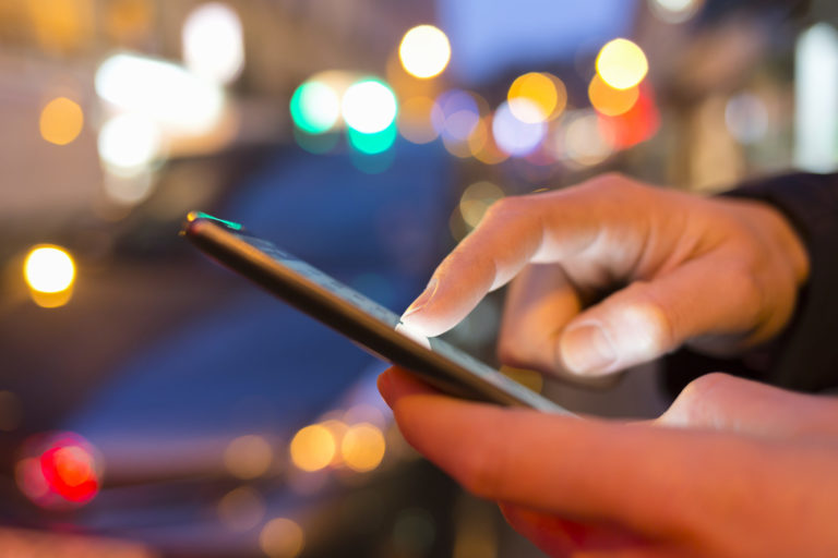 close up of male hands nightlight smartphone