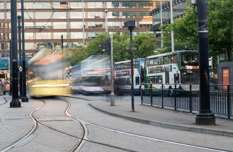 Piccadilly central bus and metro station with moving tram and buses in Piccadilly gardens at the city of Manchester in England