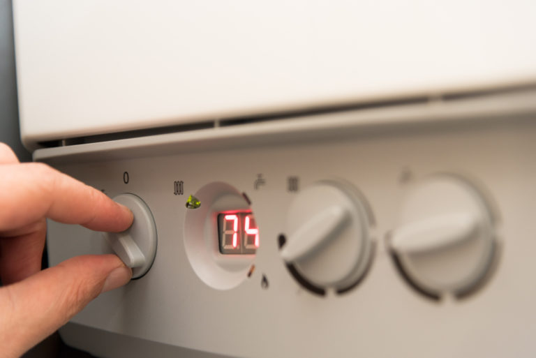 Man turning on a British Combi Gas Boiler