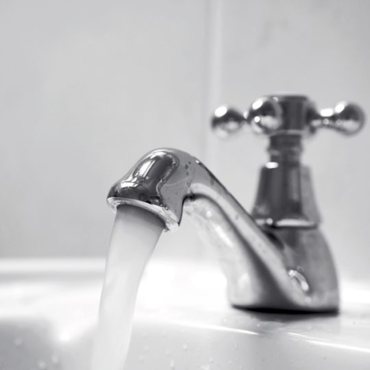 Close up of chrome tap, water running