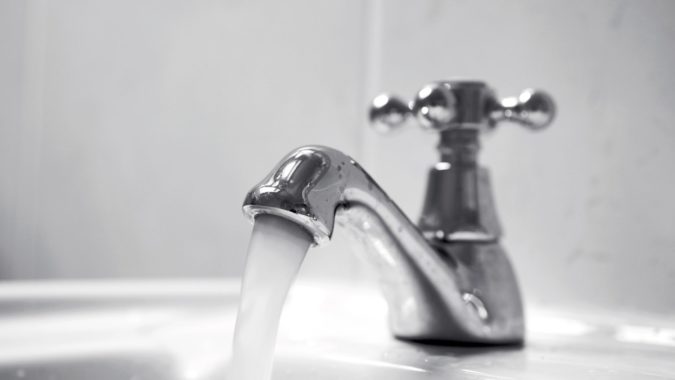 Close up of chrome tap, water running