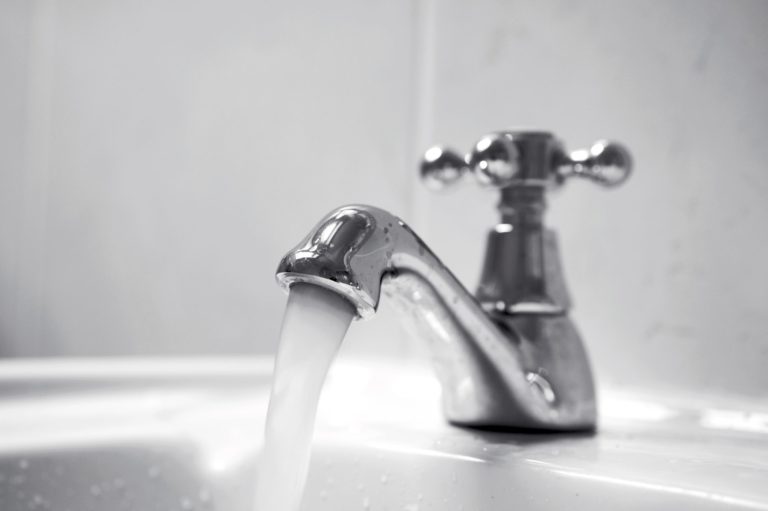 Close up of chrome tap, water running